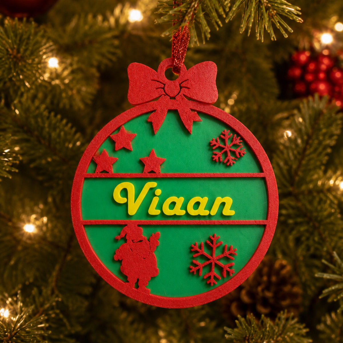 Red and green personalised Christmas bauble on the tree