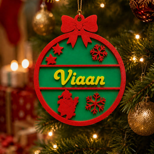 Personalised name Christmas bauble in red and green hanging on a Christmas tree